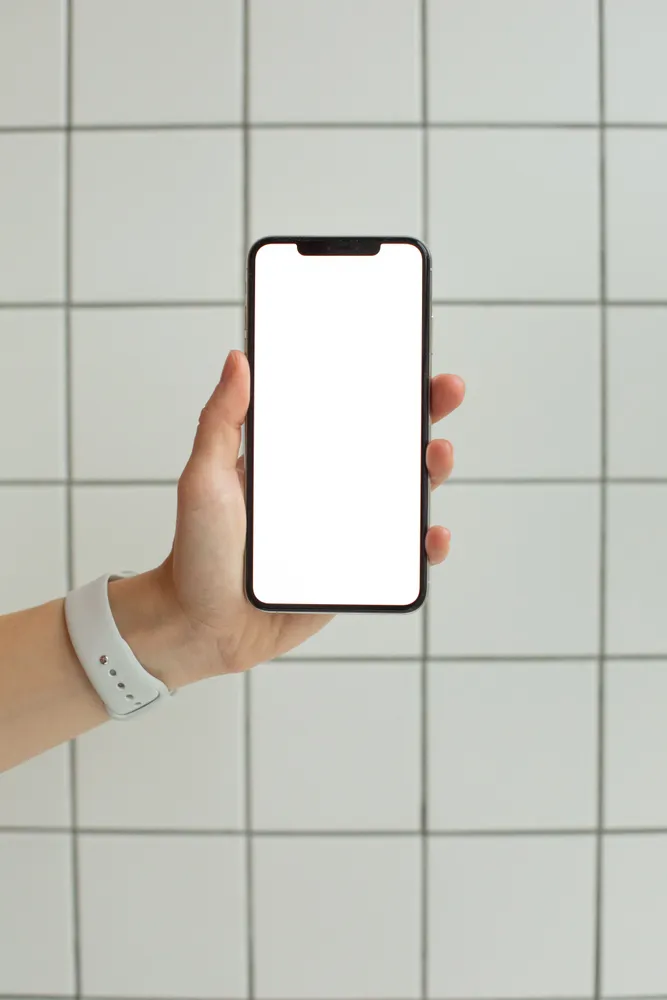 スマートフォンの画面を手に持つ様子。アプリとサーバーの接続を考えるためのイメージ