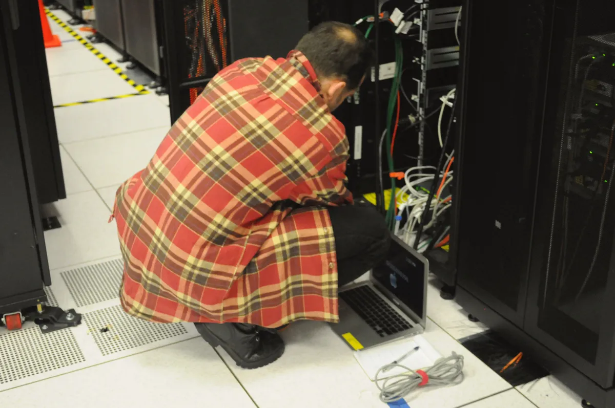データセンターのサーバーラックを確認する技術者のイメージ